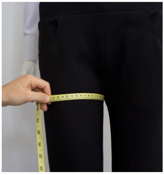 A person measuring the thigh of a personDescription automatically generated