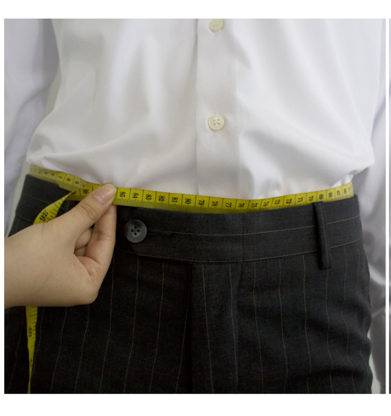 A person measuring their waistDescription automatically generated