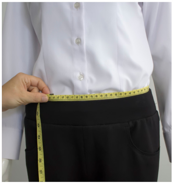 A person measuring their waistDescription automatically generated